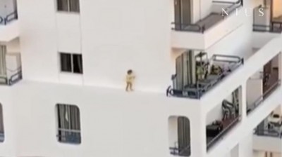 Toddler runs along a narrow ledge in Tenerife